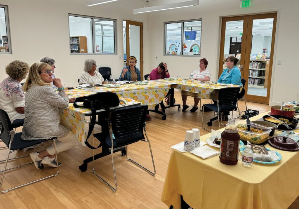 Eight women discuss “Cook Like a Pro” by Ina Garten during the inaugural meeting of their cookbook club May 22 in the Sydney Wright Room of the North Road library. Each member chooses a recipe from the selected book to prepare for a potluck. The cookbook for the June meeting is “The Pioneer Woman Cooks: The New Frontier” by Ree Drummond.