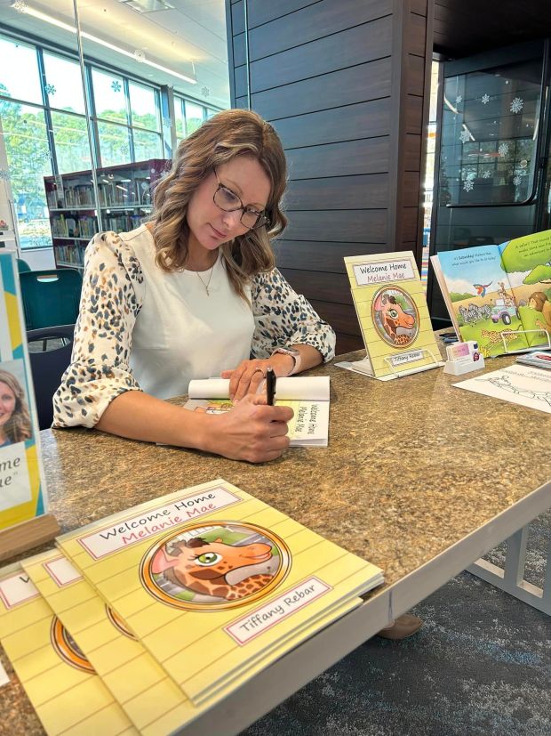 Tiffany Rebar signs a copy of her book,