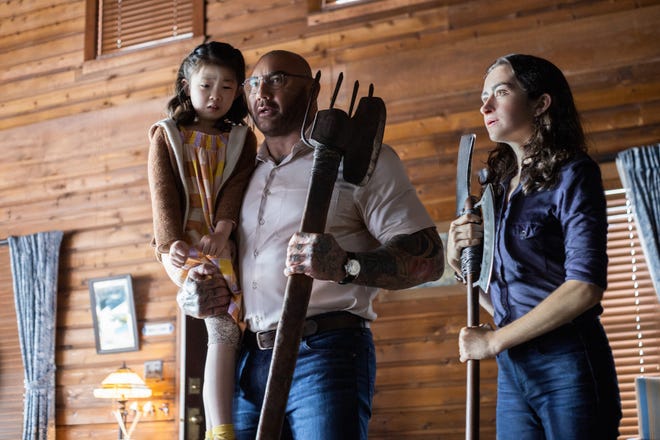 Wen (Kristen Cui, left) and her parents are held hostage and asked to make a terrible choice by a group of strangers (including Dave Bautista and Abby Quinn) in "Knock at the Cabin."