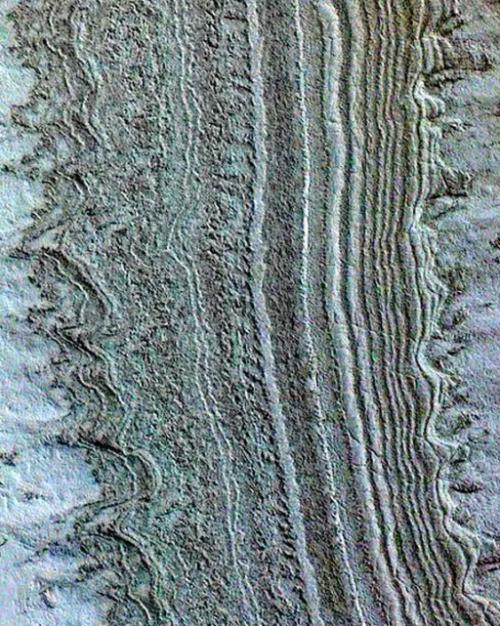 Multi-colored, uneven bands, some straight, some with curved projections, represent ice layers