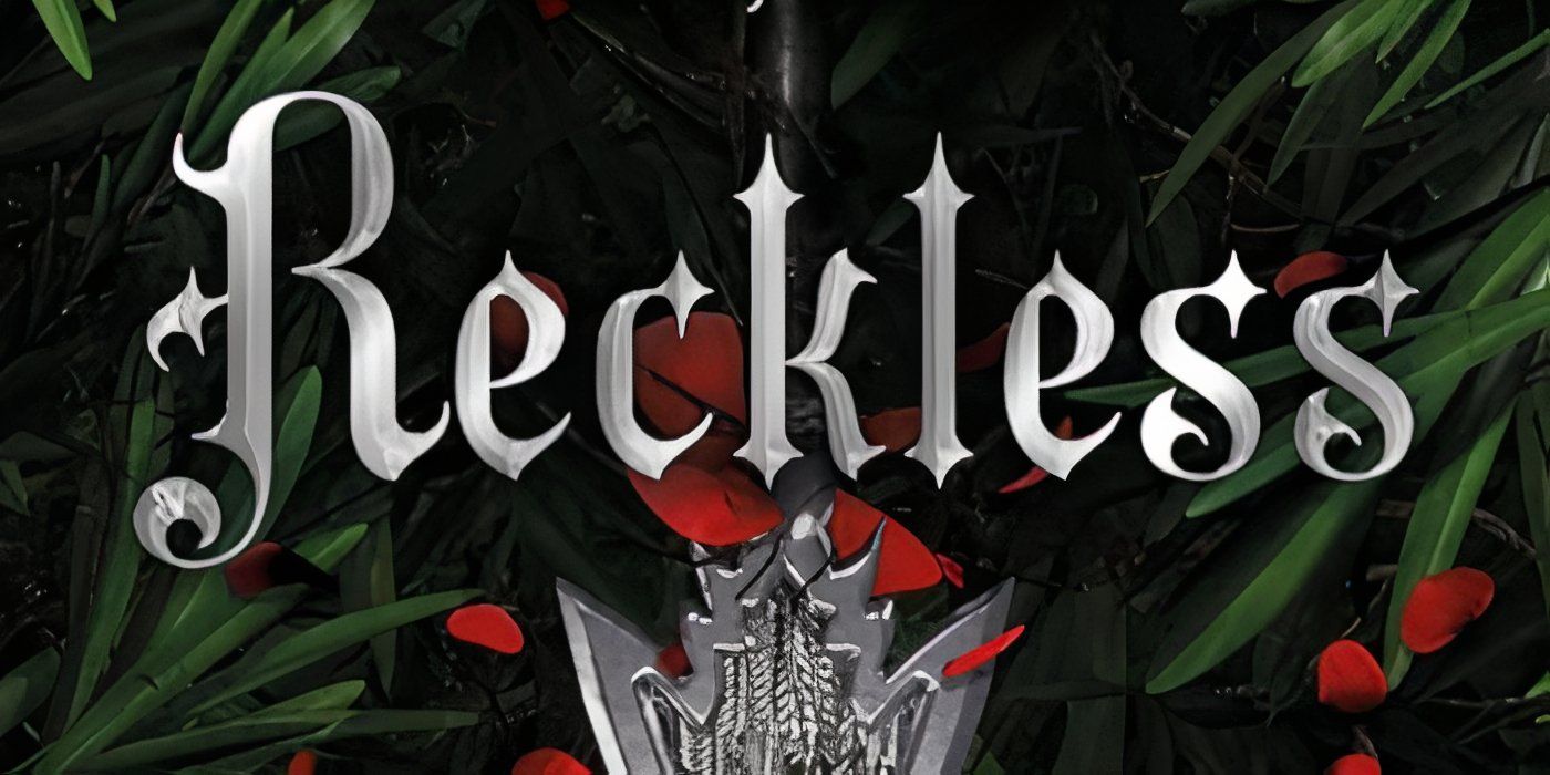 The cover of Reckless by Lauren Roberts featuring the title in silver, a silver charm, red flowers, and green leaves