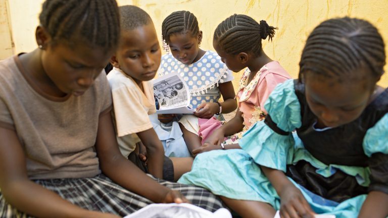 Malian schoolchildren read Bambara story books in a courtyard in Bamako, Mali.