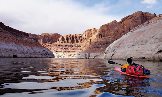 Wade McKinney paddles toward the drowned confluence of the San Juan and Colorado rivers. - ZAK PODMORE