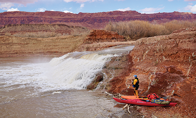 Wade McKinney stands beside Fatt Falls, which formed in the bed of Lake Powell after water levels began dropping in 2000. - ZAK PODMORE