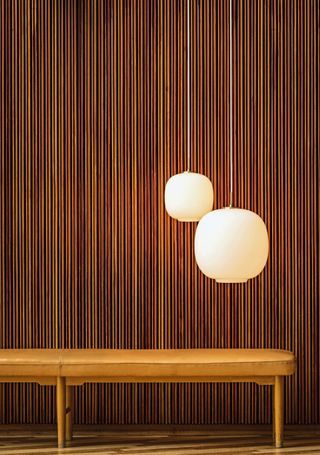 Vilhelm Lauritzen’s VL45 Radiohus pendant, reintroduced into Louis Poulsen’s catalogue in 2016 and photographed at the Radio House, for which it was initially designed. Underneath is the VLA75 Foyer bench, also by the architect.
